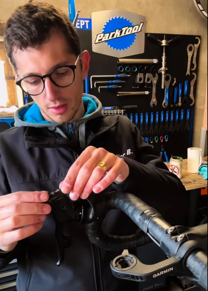 Benjamin, gérant de L'Atelier B. avec un vélo électrique Granville